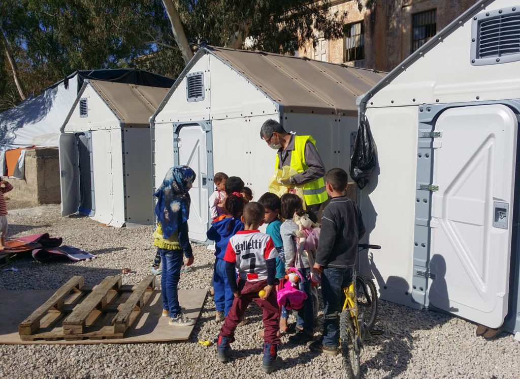 Titan Greece supports refugees in camps: snapshot of a volunteer giving food to chidren