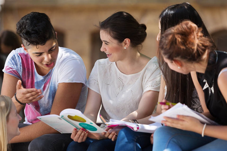 Image of students seating on a bench exchanging views to illustrate TITAN 's support of local communities and youth initiatives