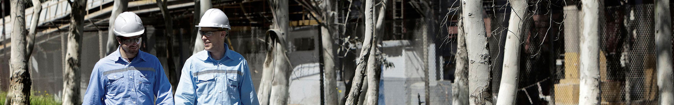TITAN employees with protective gear, helmet and glasses walking in a plant