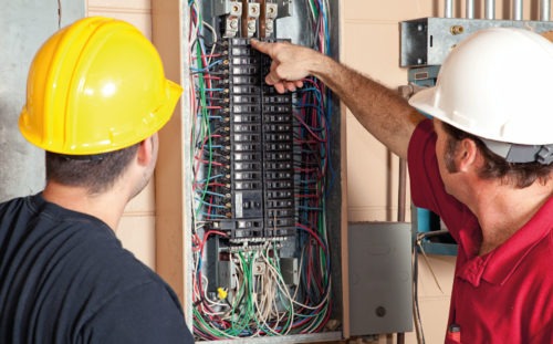 TITAN case study on supporting Start-Ups in Greece: Two workers with helmets looking at an electric board