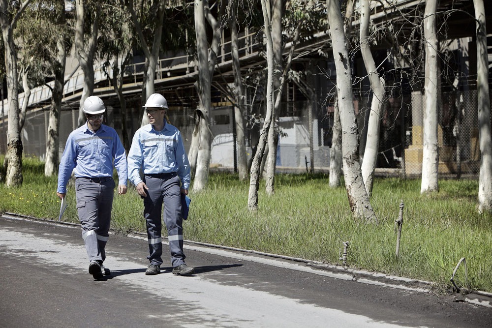 TITAN employees with protective gear, helmet and glasses walking in a plant