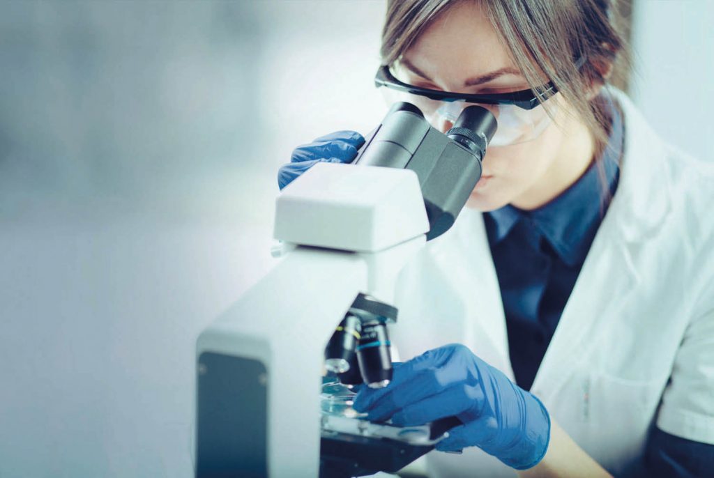 A woman scientist looking into a microscope